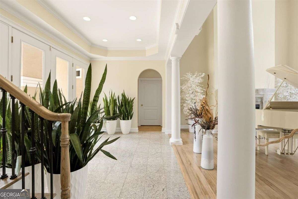 Grand foyer with columns, staircase, and bright open interior at 124 Fairway Run in Forsyth, GA