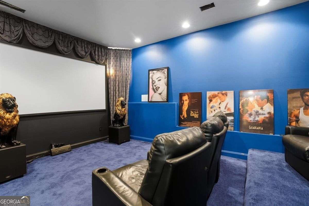 Home theater with projection screen and leather seating at 124 Fairway Run in Forsyth, Georgia