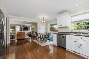 Kitchen with white cabinetry, hardwood floors and breakfast area at 176 Arlington Row in Castlegate, Macon GA